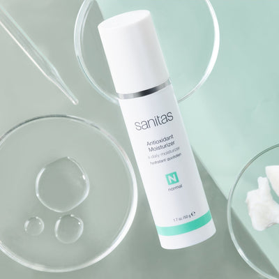 antioxidant moisturizer on green table with dropper and dish