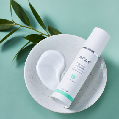 balancing moisturizer on white plate with plant next to it