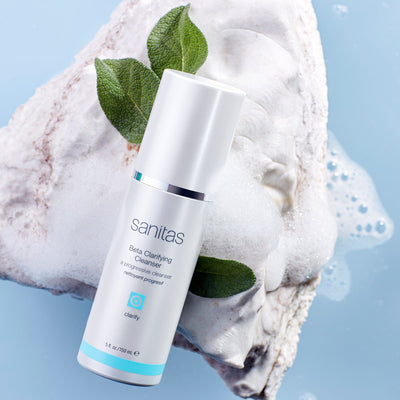 beta clarifying cleanser on rock with plant behind it
