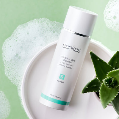 sensitive skin cleanser on white plate with plant next to it