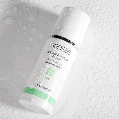 natural moisture factor 30 mL on white table with water droplets on it 