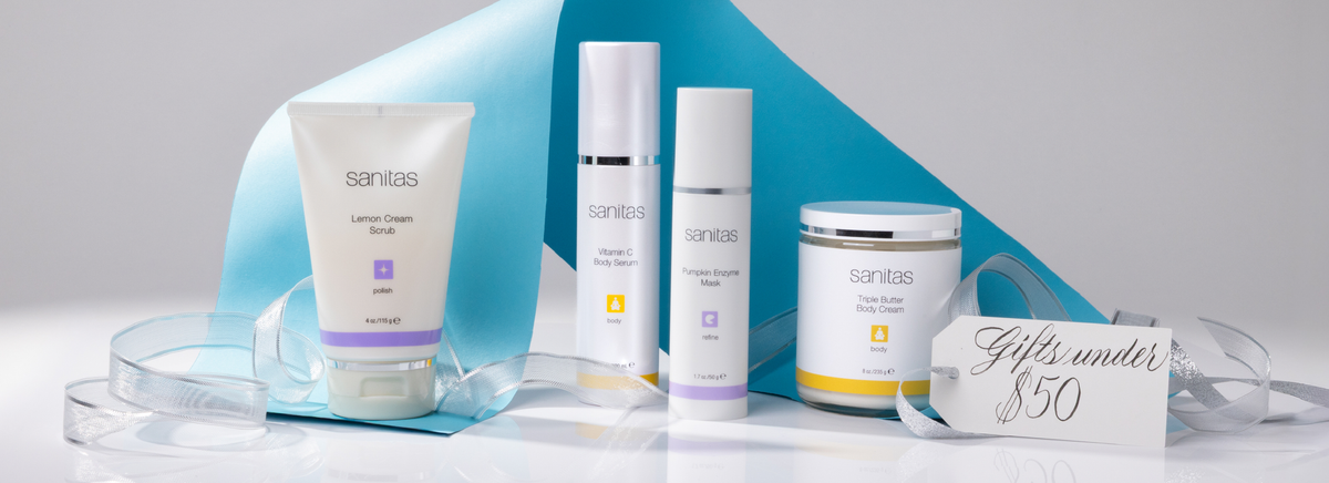 Sanitas Skincare products styled with a blue and grey background and silver ribbon with a 'Gifts under $50' tag.